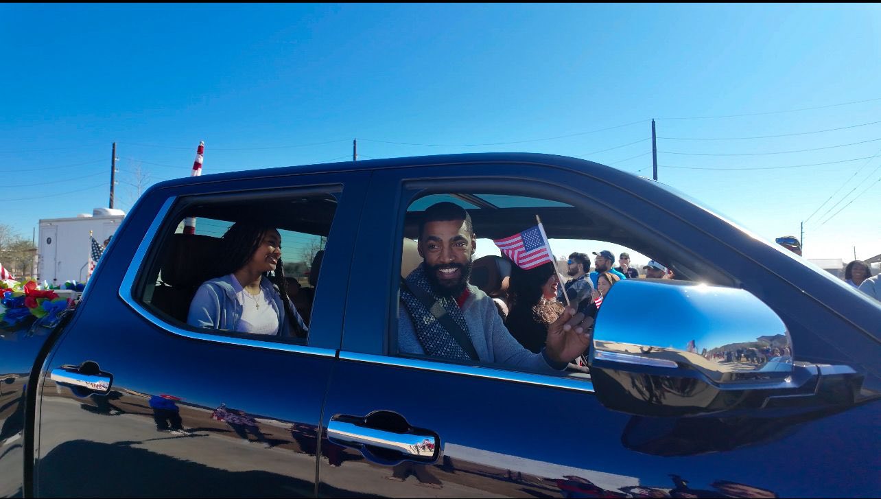 Navy veteran Gabriel George waving American flag in a car while celebrating mortgage-free home gift from Building Homes for Heroes at Pomona by Hillwood in Manvel, TX Navy veteran Gabriel George waving American flag in a car while celebrating mortgage-free home gift from Building Homes for Heroes at Pomona by Hillwood in Manvel, TX