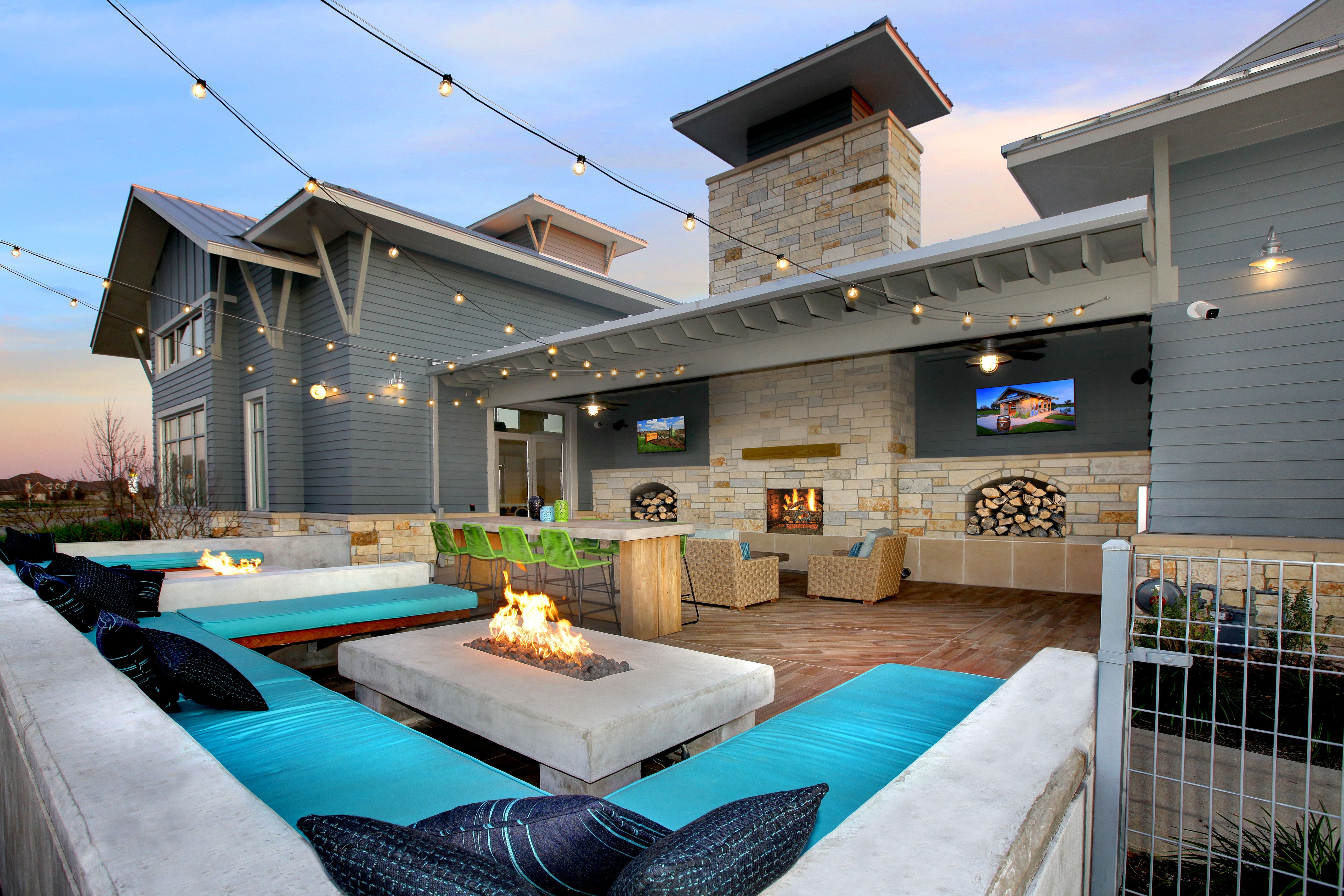 View of Camp Pomona amenity with outdoor lounge area, fire pit, string lights, and big screen TVs. View of Camp Pomona amenity with outdoor lounge area, fire pit, string lights, and big screen TVs.