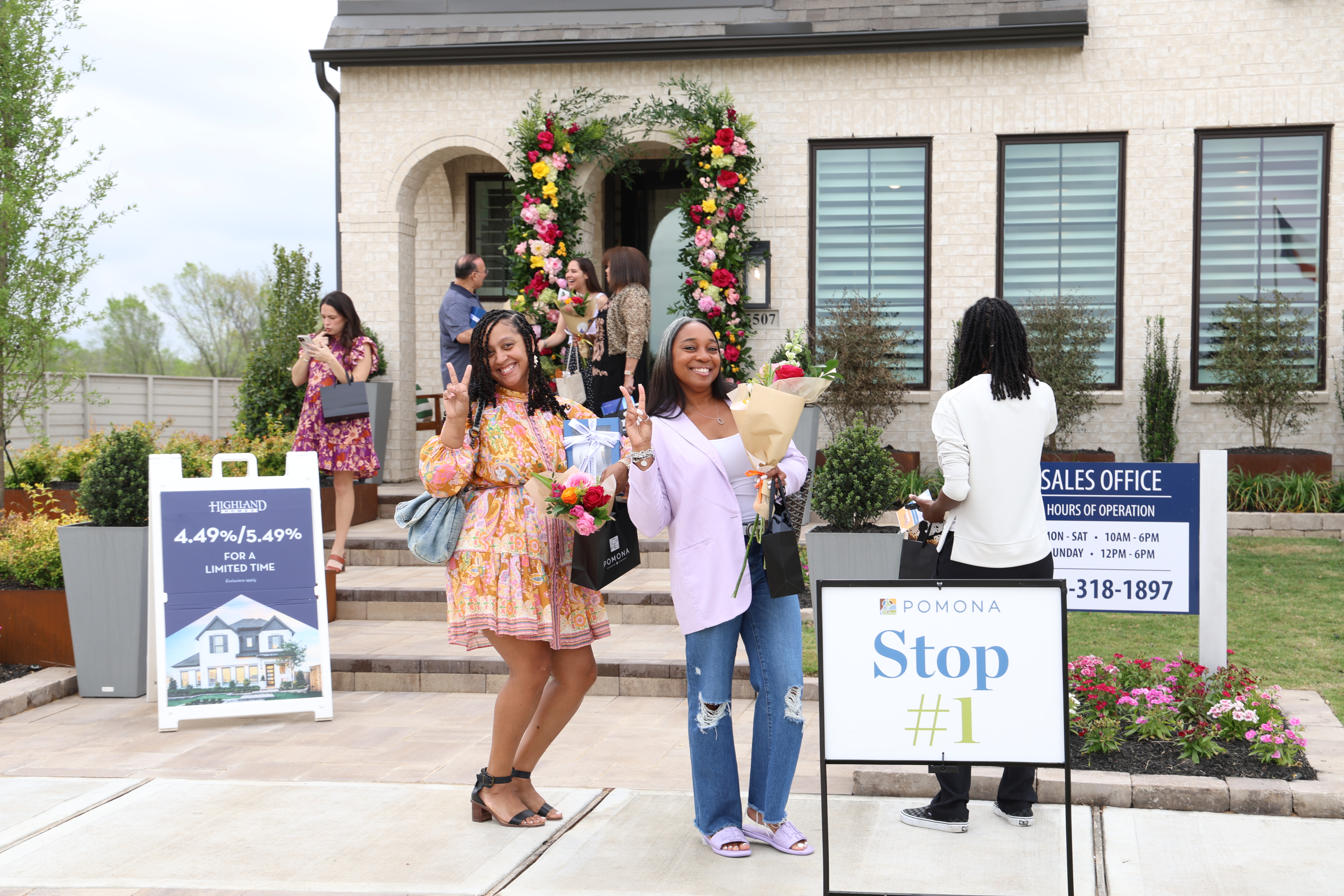 Two realtors posing outside of new model homes during tour event at Pomona Two realtors posing outside of new model homes during tour event at Pomona